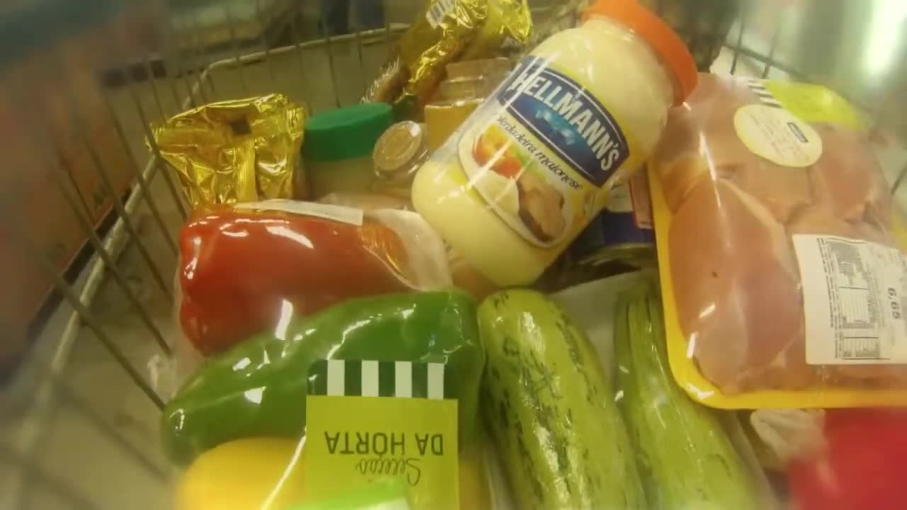 A shopping cart with groceries and a jar of Hellmann's
